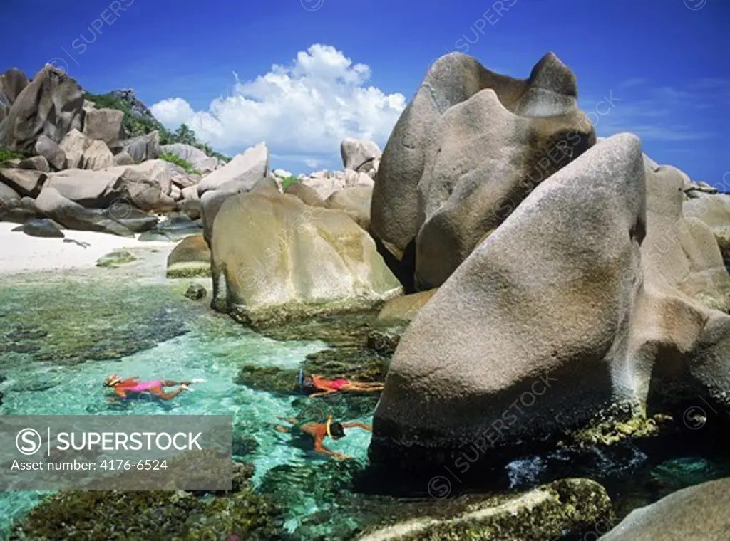 Tourists snorkling in tidepools on La Digue Island in Seychelles