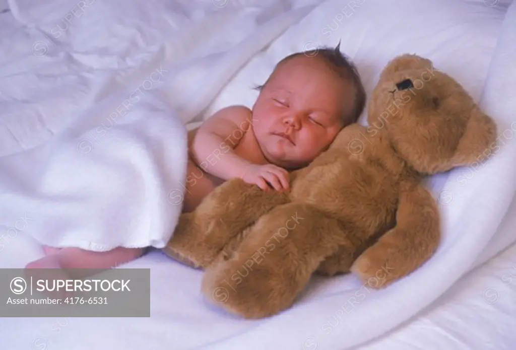 Baby sleeping with favorite teddy bear