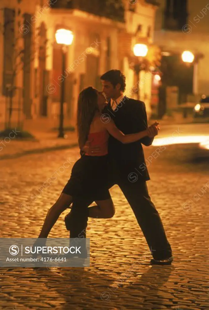 Couple tango dancing at night on streets of San Telmo in Buenos Aires