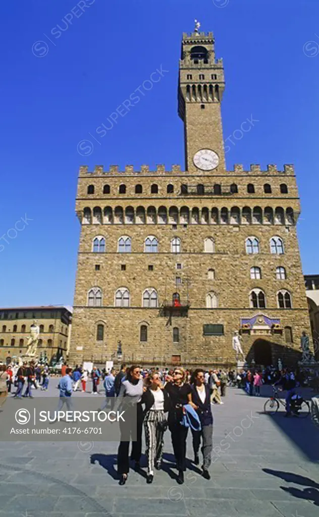 Four female friends on Piazza della Signoria with Palazzo Vecchio in Florence