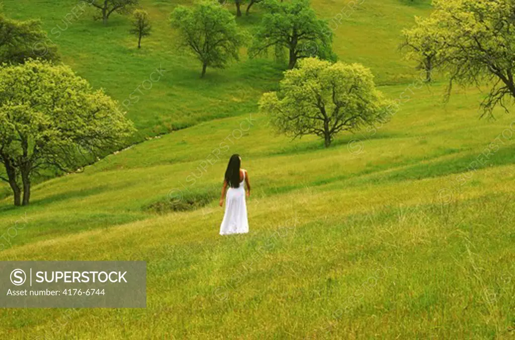 Woman wearing white dress in field of pure green