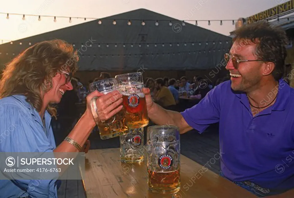 Couple having steins of beer at Oktoberfest in Munich Germany