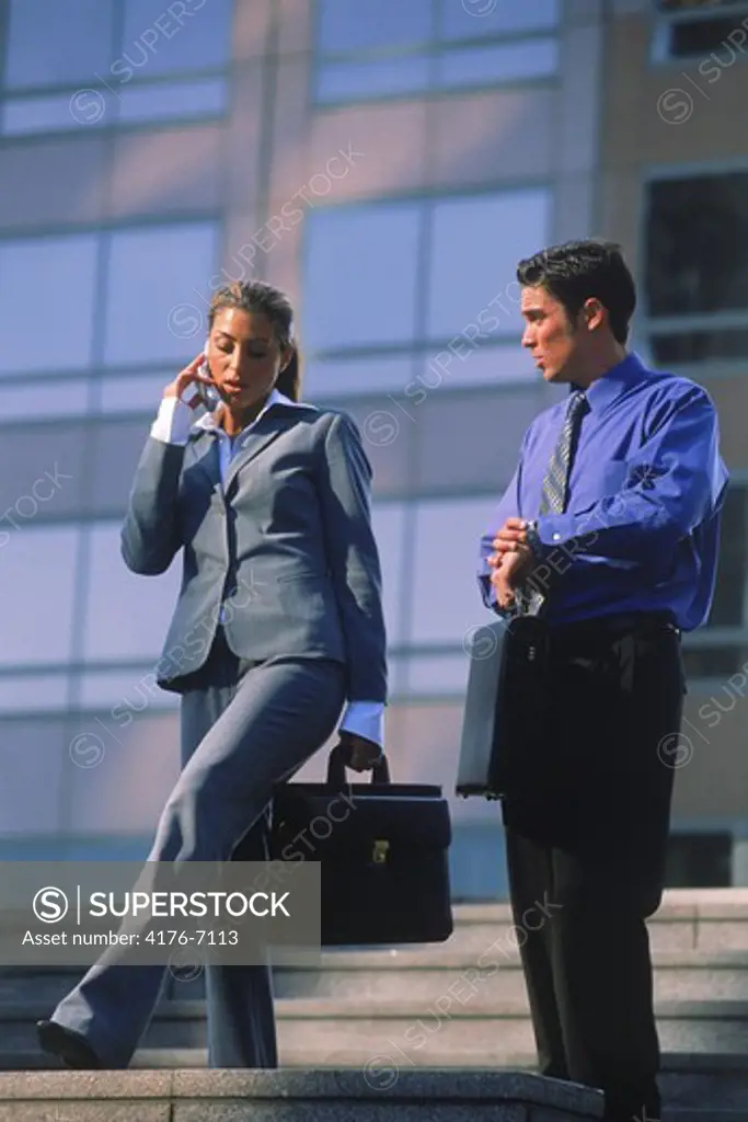 Businessman and women with briefcases on steps in Los Angeles