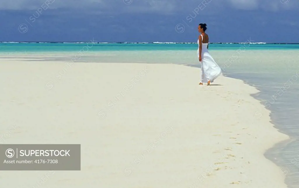 Woman in white dress on sand bar in Aitutaki lagoon