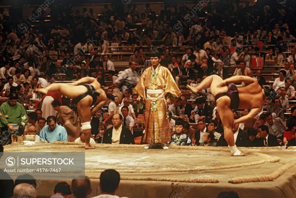 Sumo wrestlers pre fight ceremony of leg stamping in ring or dohyo