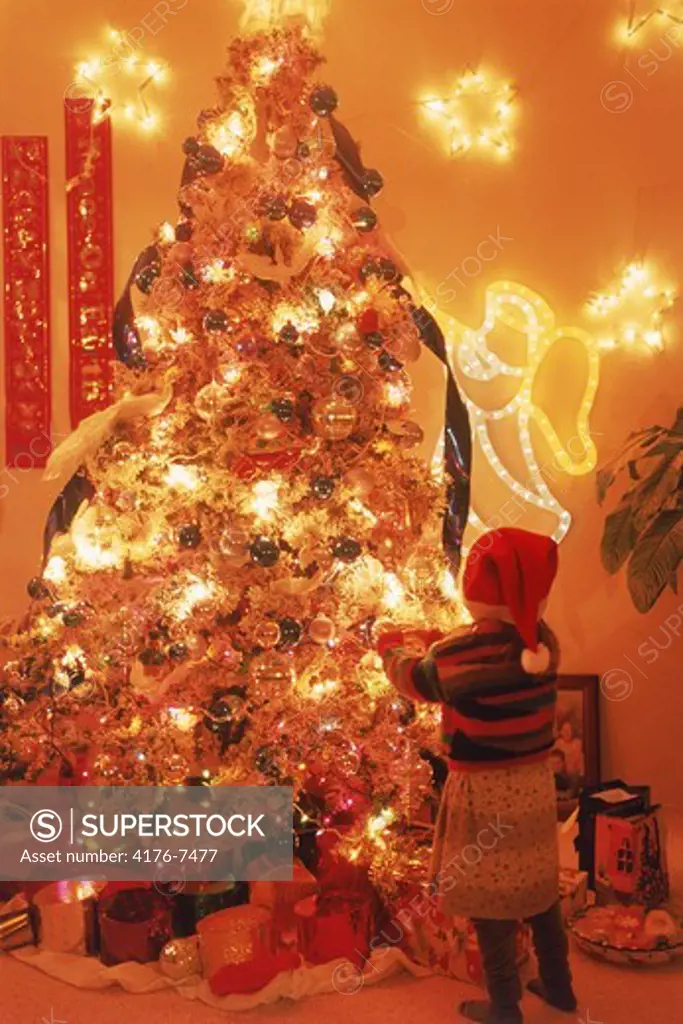 Young girl and brightly lit Christmas tree