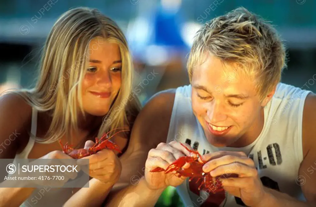 Young couple eating crayfish in August in Sweden