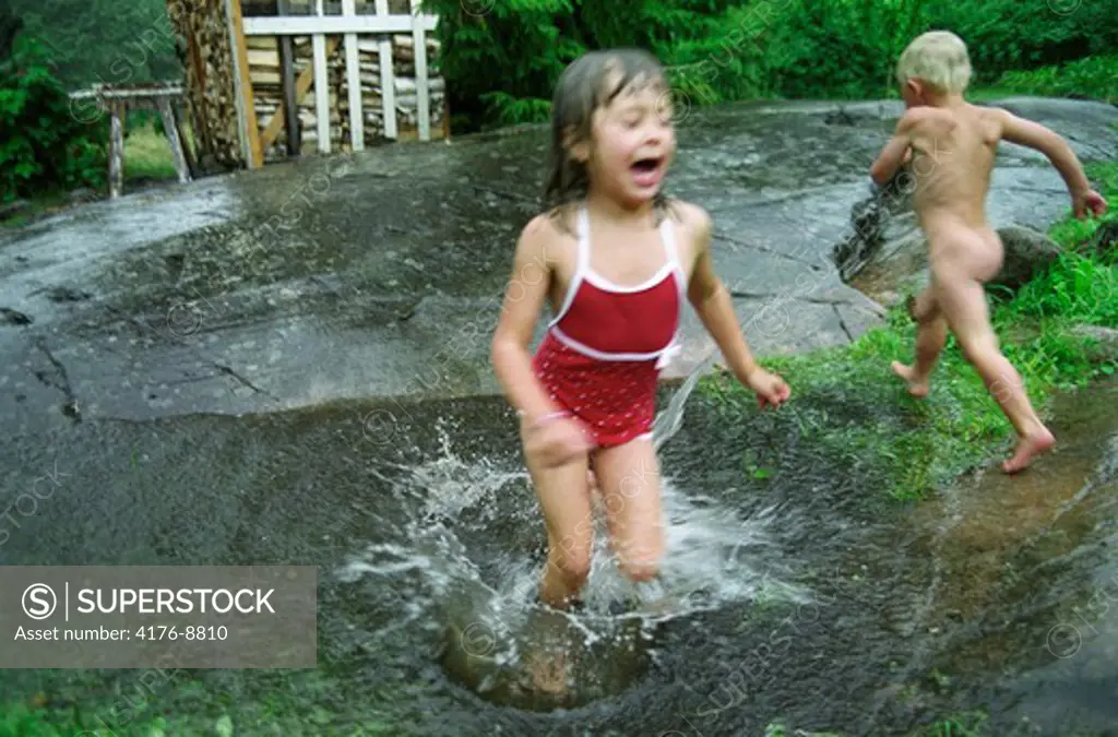 Children running outdoors in the rain. Sweden