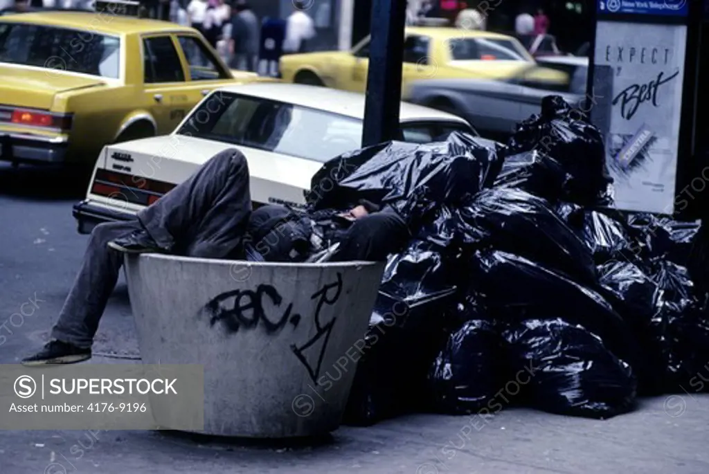 A person lying in the trash can