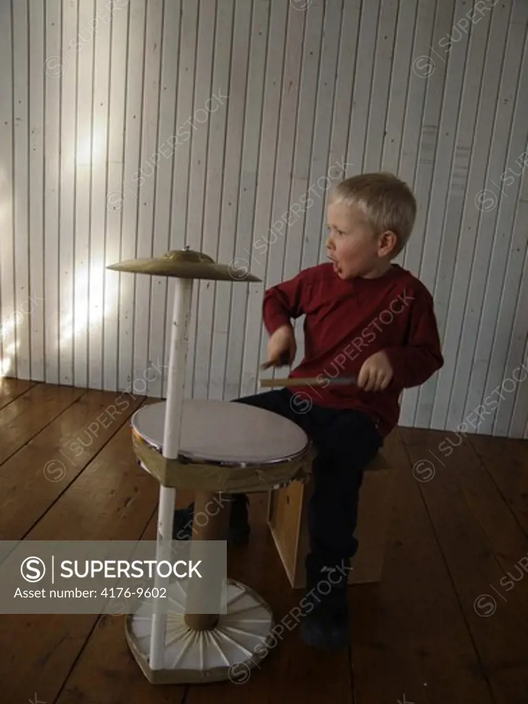 A five-year-old boy beating a toy drum. Sweden