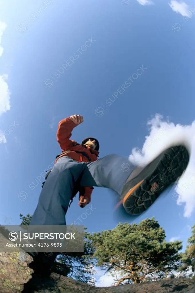Low angle view of a person walking against cloudy sky