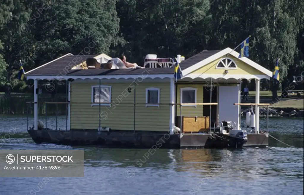 Swedish flags on a houseboat cruising in a river