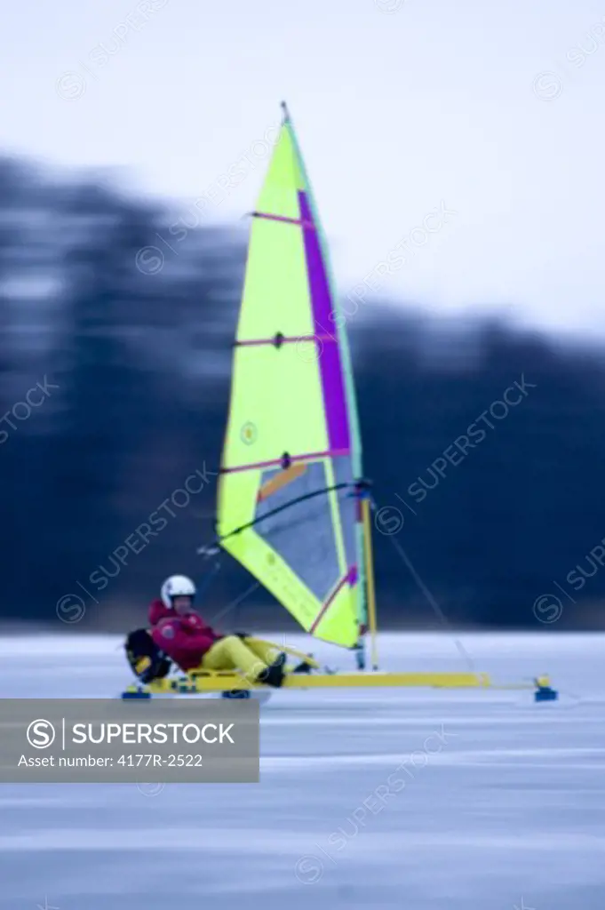 Side profile of a man sailing a boat on a frozen lake