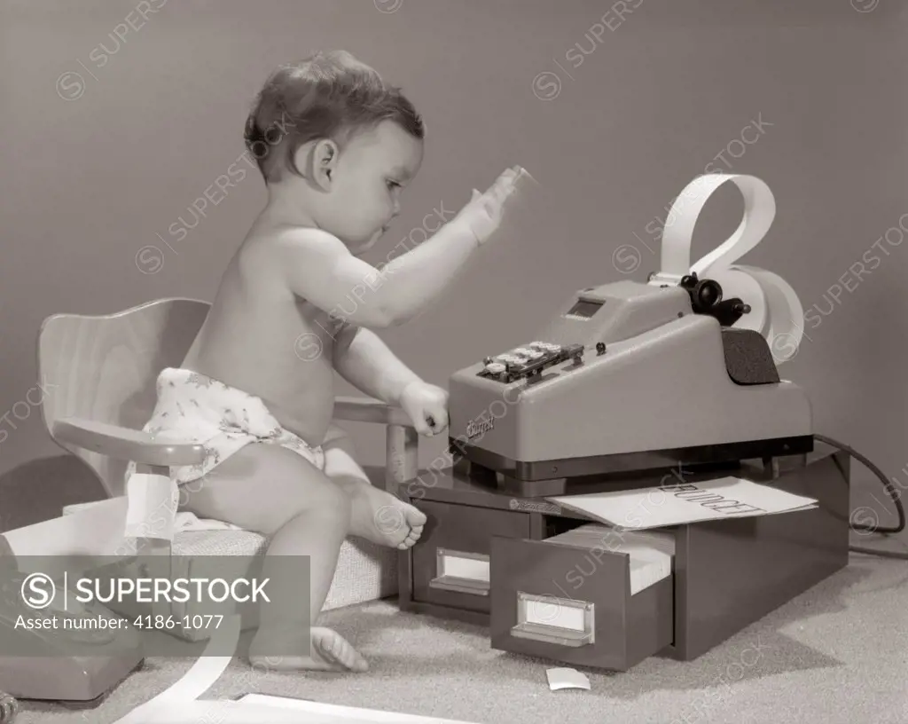 1960S Baby Seated In Small Chair Hitting Keys On Office Adding Machine On Top Of Small File Drawers