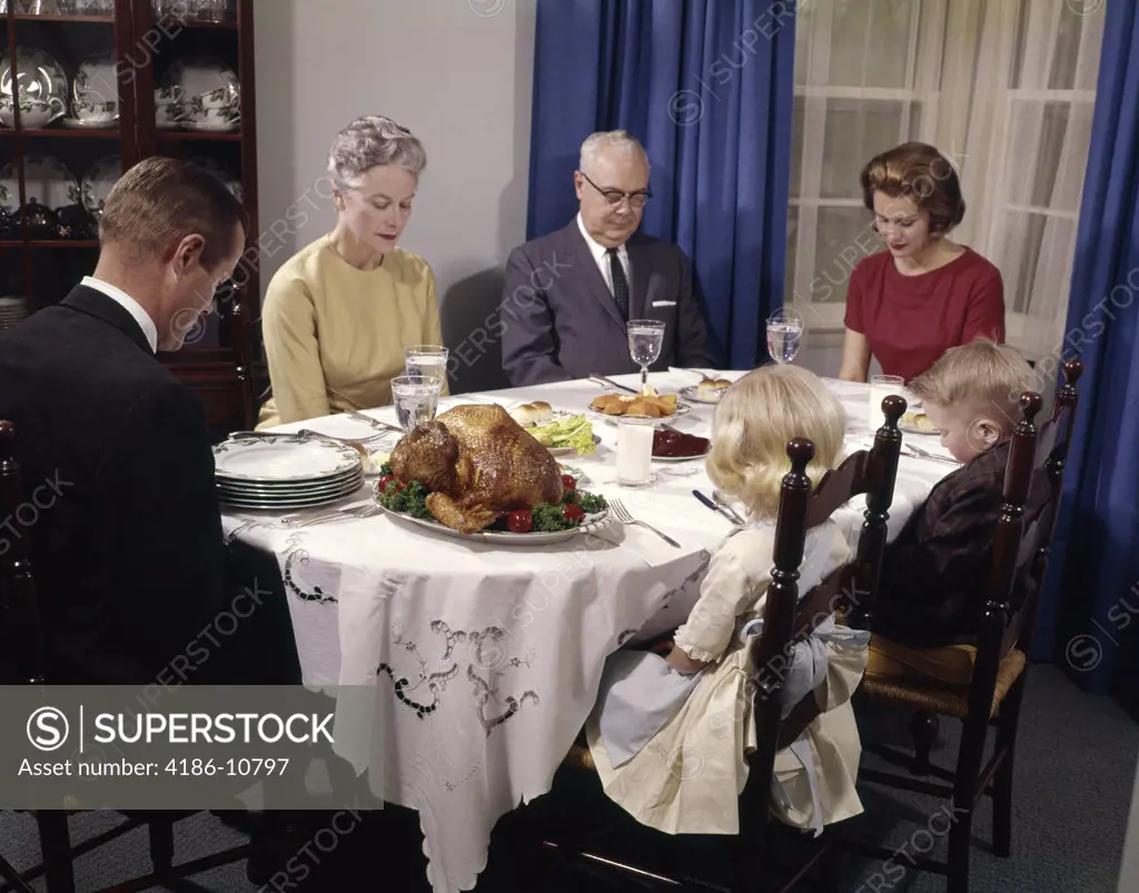 1960S Three Generation Family Saying Grace At Thanksgiving Dinner