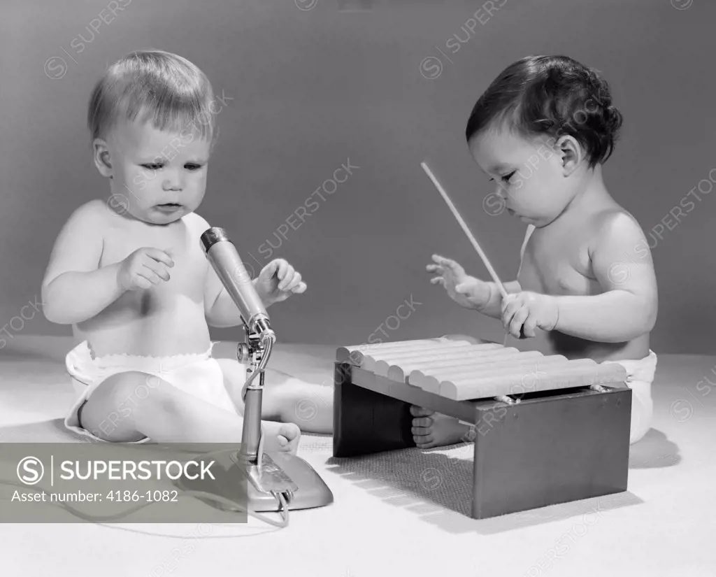 1960S Two Babies In Diapers With Microphone And Toy Xylophone Musical Instrument Playing Together