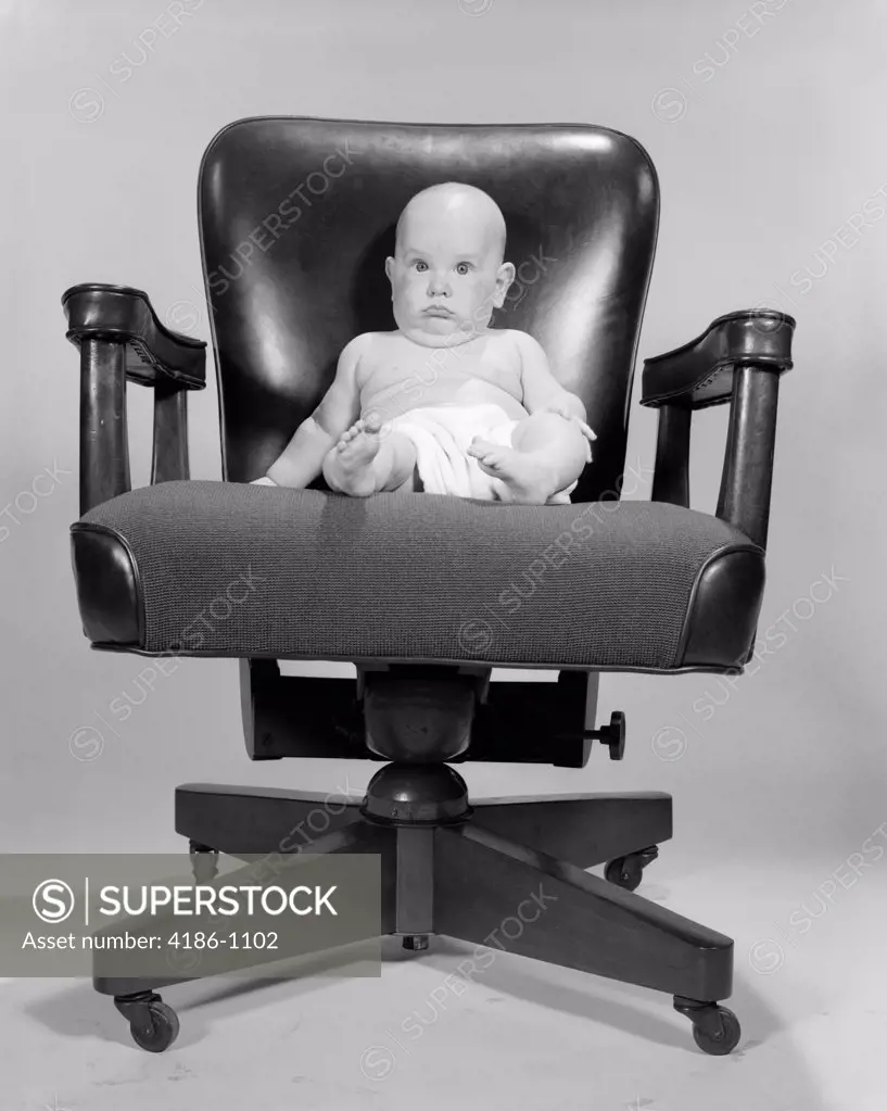 1960S Portrait Of Chubby Bald Baby In Diaper Sitting In Executive Office Chair