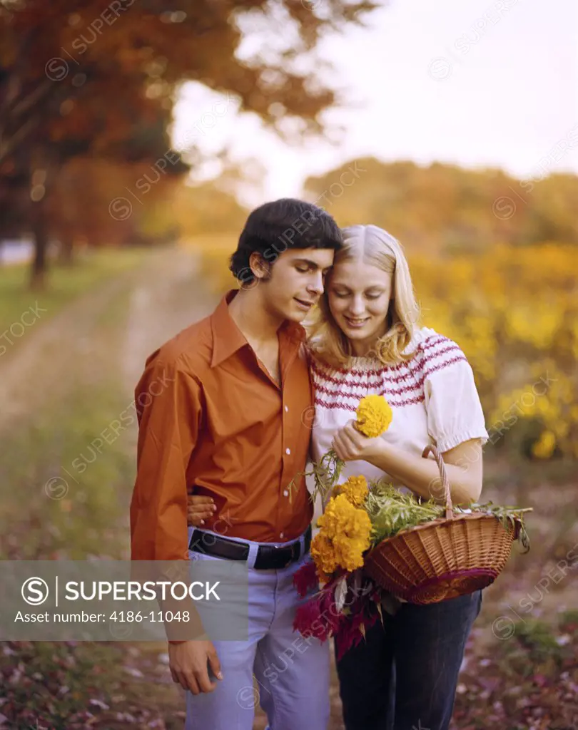 1970S Affectionate Young Couple With Basket Of Flowers On Country Road Autumn Romantic Man Woman