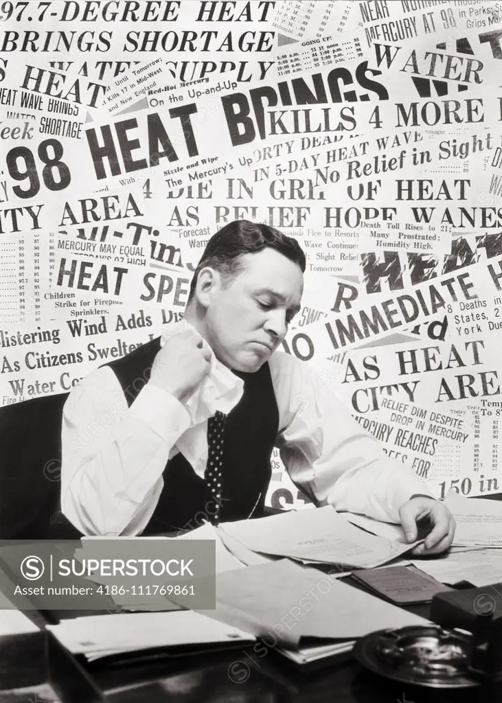 1930s SWEATING MAN SITTING AT DESK READING PAPERS USING HANDKERCHIEF WIPING HIS NECK BACKGROUND OF HEAT WAVE NEWSPAPER HEADLINES