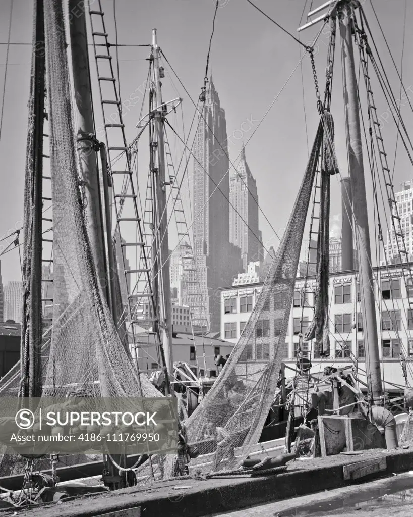 1930s 1940s MIDTOWN SKYSCRAPERS SEEN THROUGH FULTON FISH MARKET PIER FISHING  BOATS DOWNTOWN LOWER MANHATTAN NYC NEW YORK USA - SuperStock