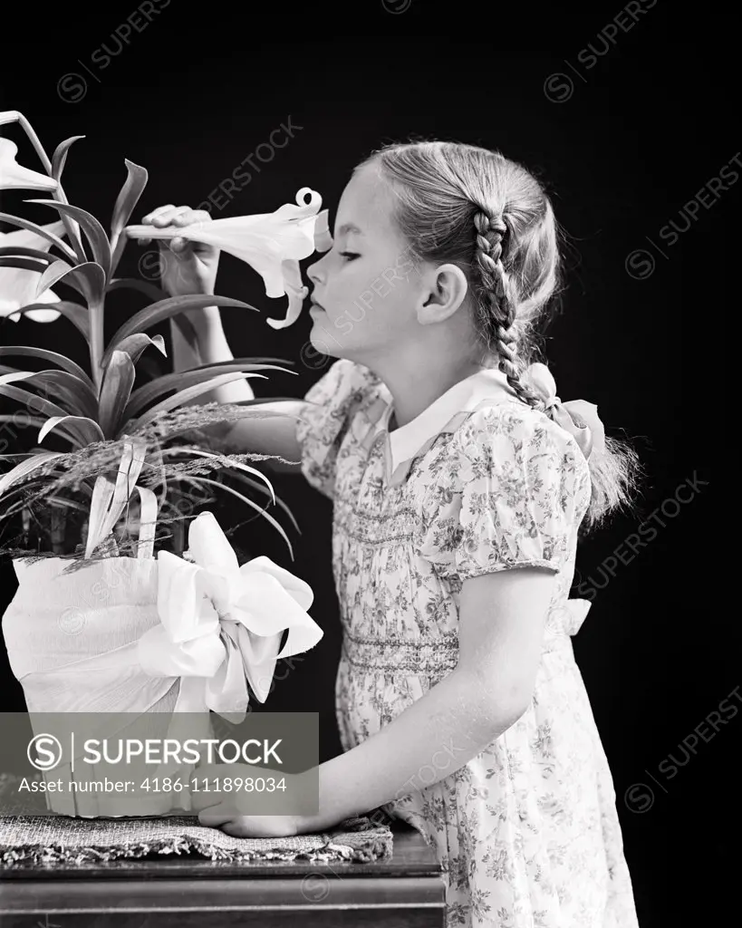 1940s GIRL WITH BRAIDS SNIFFING SMELLING SCENT OF A POTTED EASTER LILY