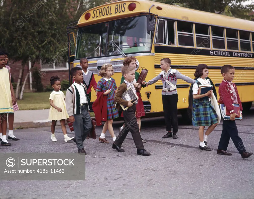 1960S Elementary School Children Cross Street Past Safety Guard With Arms Out Bus Boy Girl