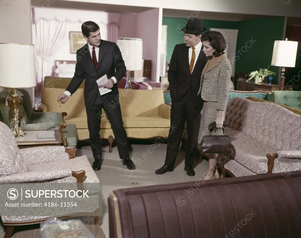 1960S Couple With Salesman Looking At Showroom Furniture In Department Store Nostalgia Tufted Man Woman