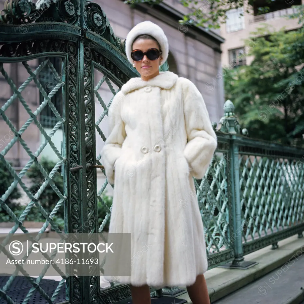 1960S Woman Wearing White Mink Fur Coat Hat Sunglasses By Wrought Iron Gate