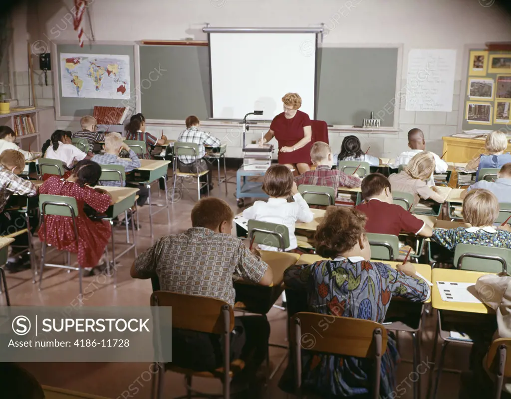 1960S Teacher With Class In Schoolroom With Audio Visual Machine Equipment