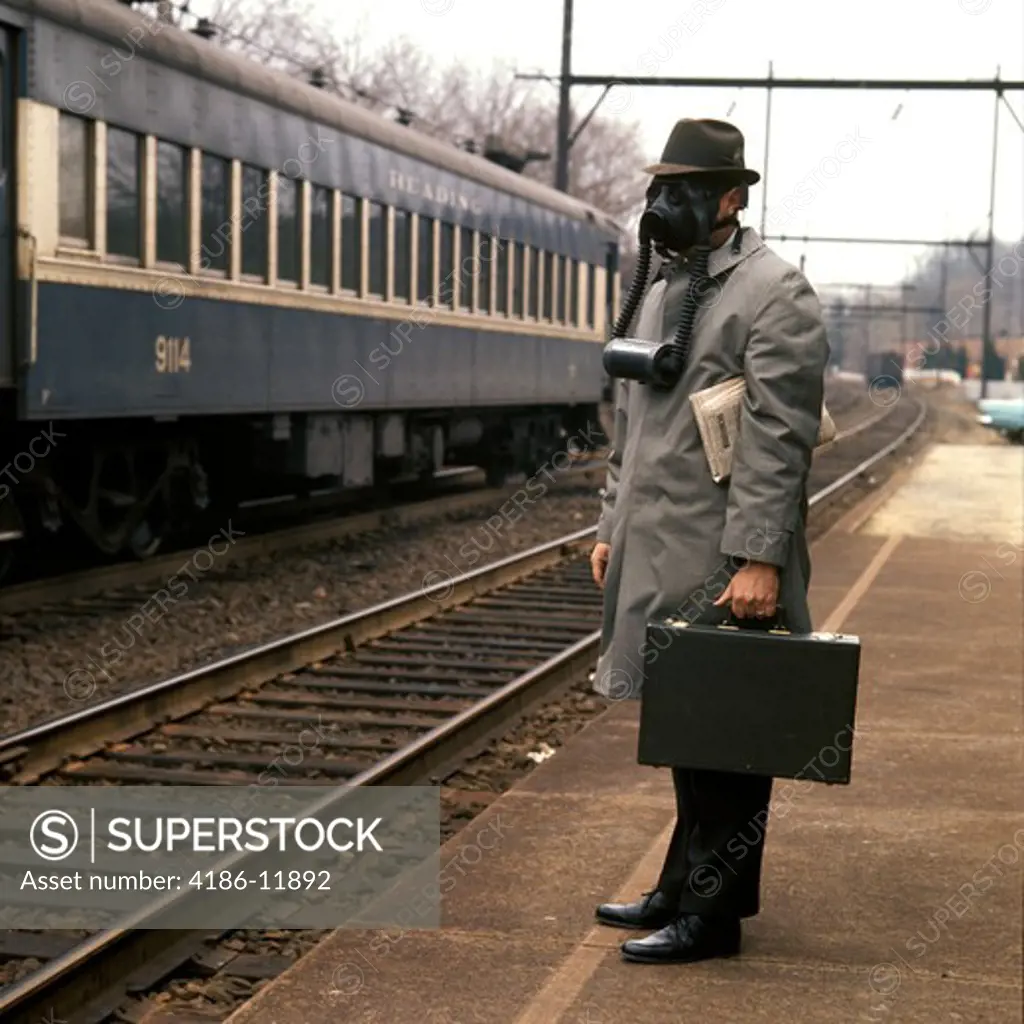 1970S Businessman Man Briefcase Train Station Railroad Platform Wearing Gas Mask Environment Smog