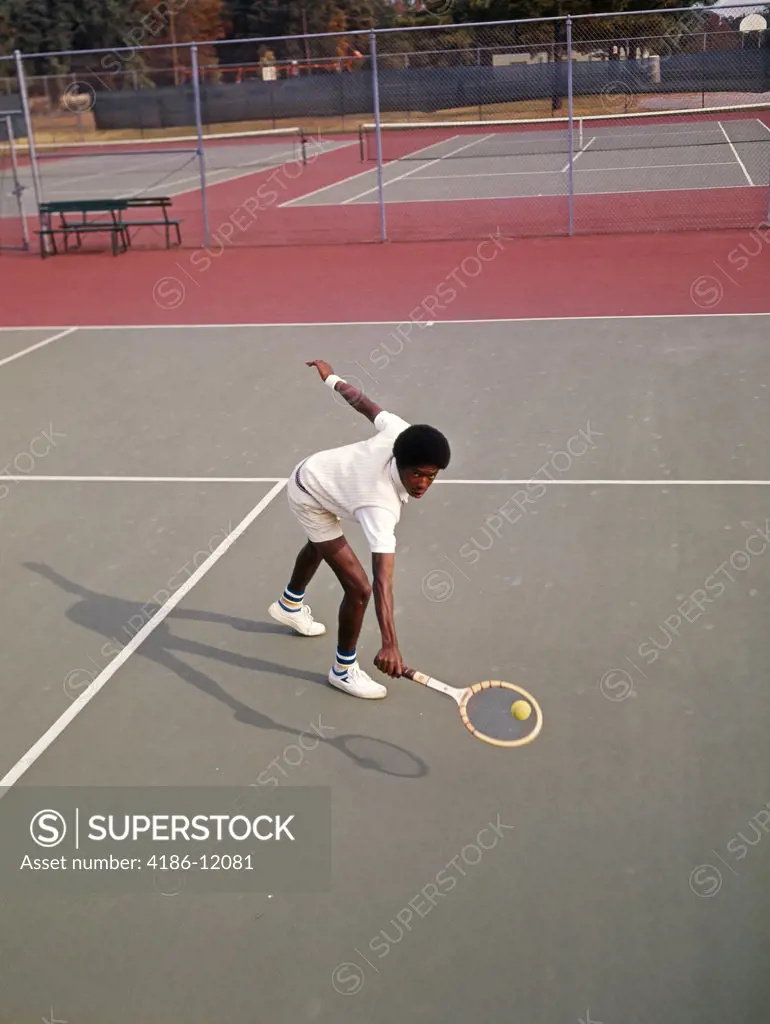 1970 1970S Man African-American Playing Tennis Leaning Over About To Hit Ball Low Backhand Retro Vintage