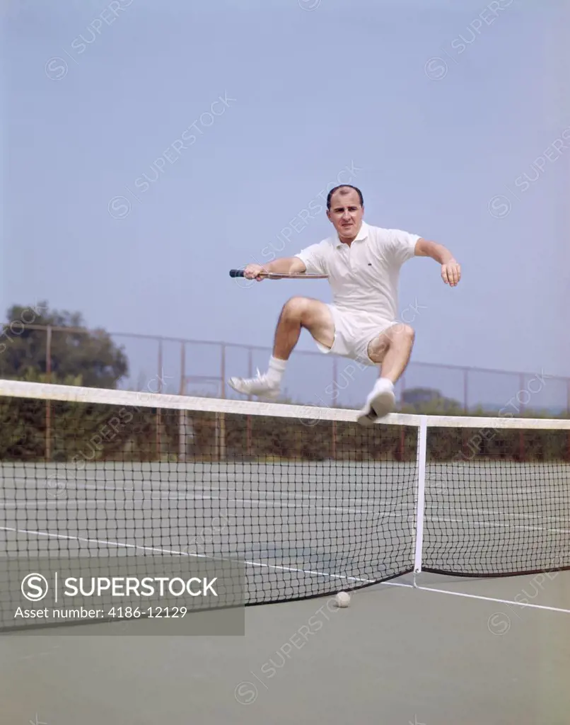 1970S Middle Aged Man Jumping Over Net On Tennis Court Balding Fitness Agile Wellness Lifestyle
