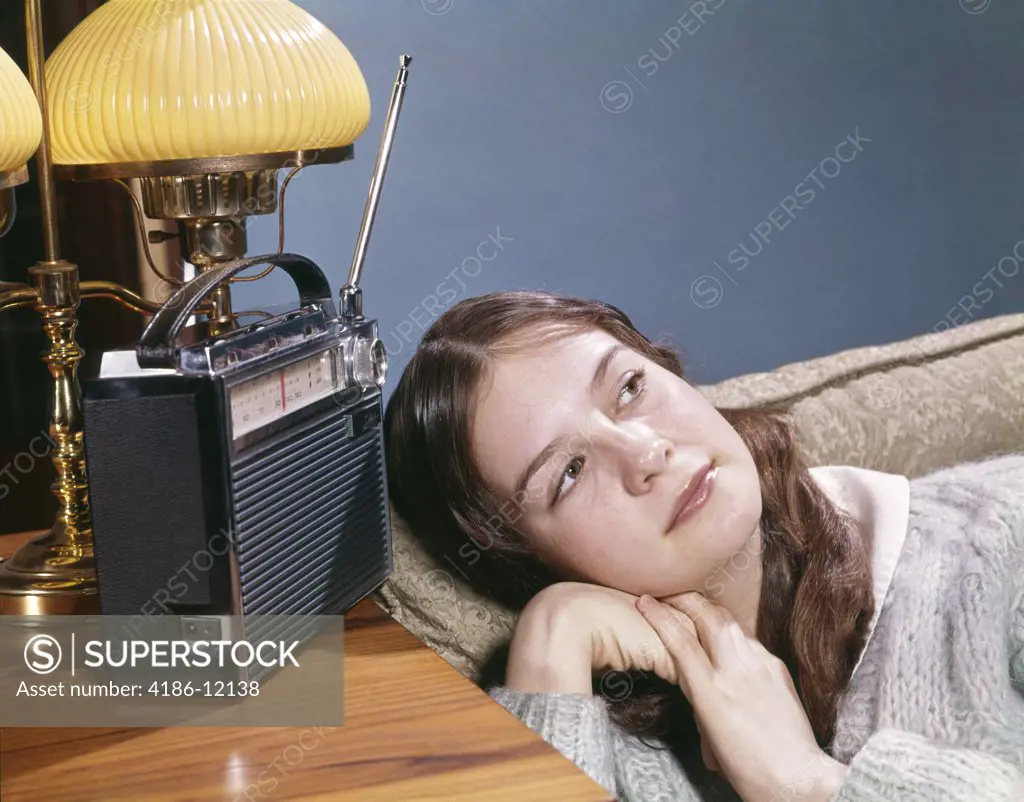 1960S Teen Girl Lying On Couch Listening To Music On Portable Transistor Radio