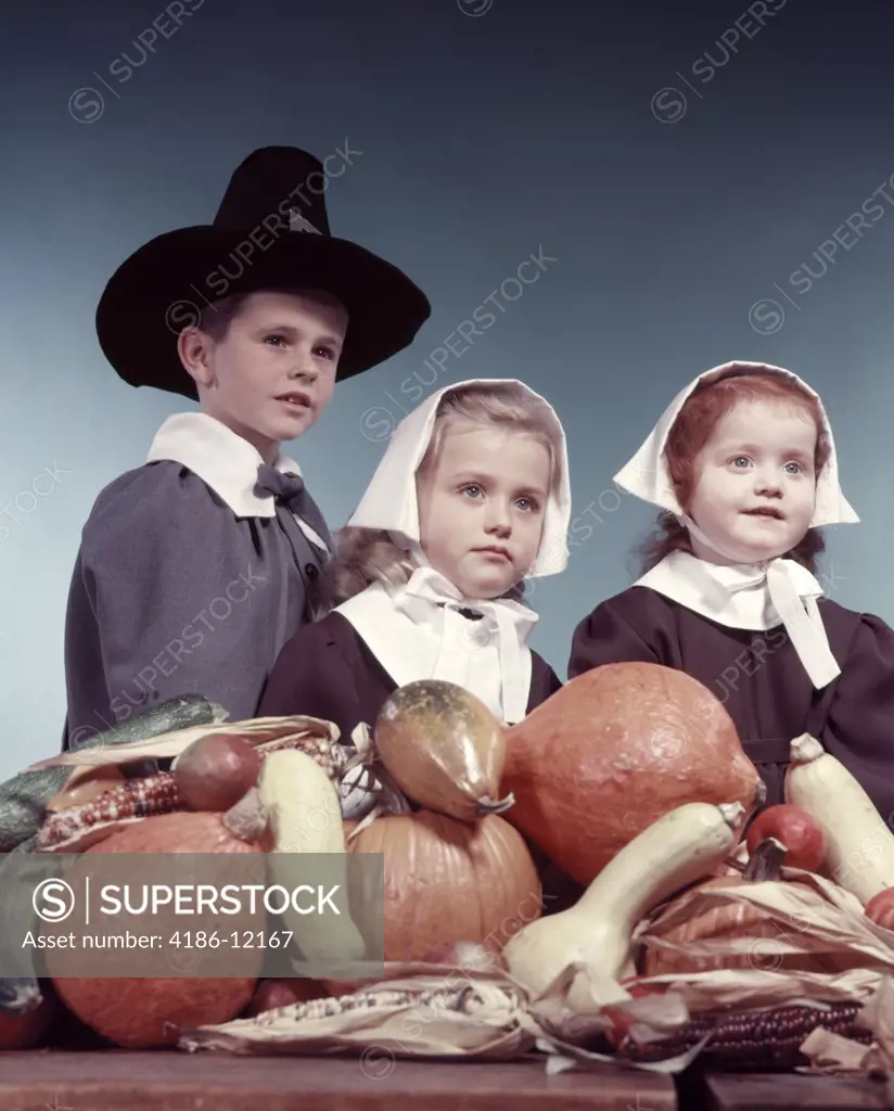 1950S 3 Children 2 Girls 1 Boy Dressed In Puritan Pilgrims Costumes Pumpkin Harvest Vegetables In Foreground
