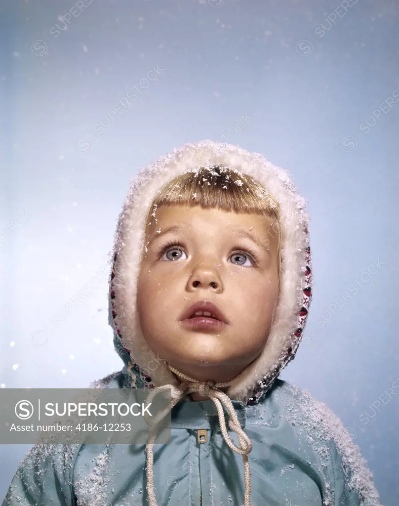 1960S Cold Little Blond Girl In Winter Coat And Hood Looking Up At Falling Snow