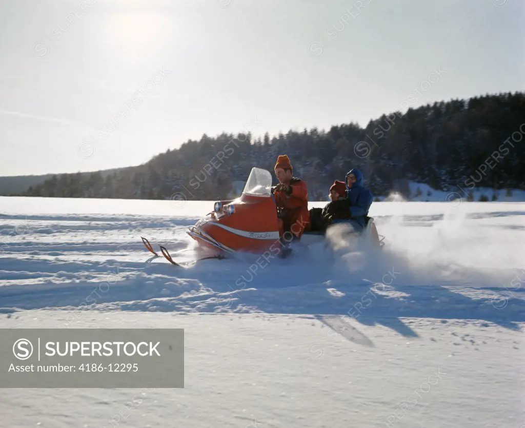1960S Family Riding On Snowmobile In Snowy Winter Landscape