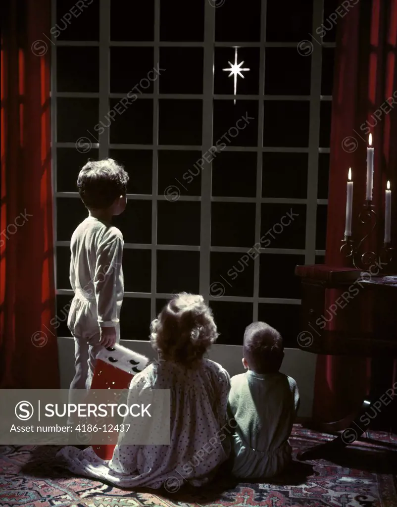 1950S 3 Children 2 Boys 2 Girl Pajamas Look Out French Doors To Star Bethlehem Christmas Eve Boy Holds Stocking Studio