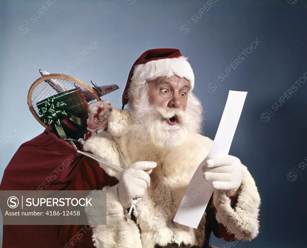 1950S 1960S 1970'S Surprised Santa Claus Carrying Sack Of Toys Reading List Studio Indoor