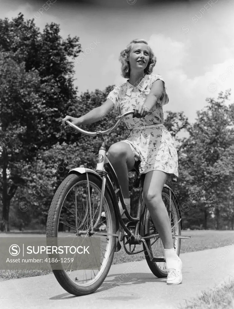 1930S 1940S Blond Girl Riding Bike On Sidewalk