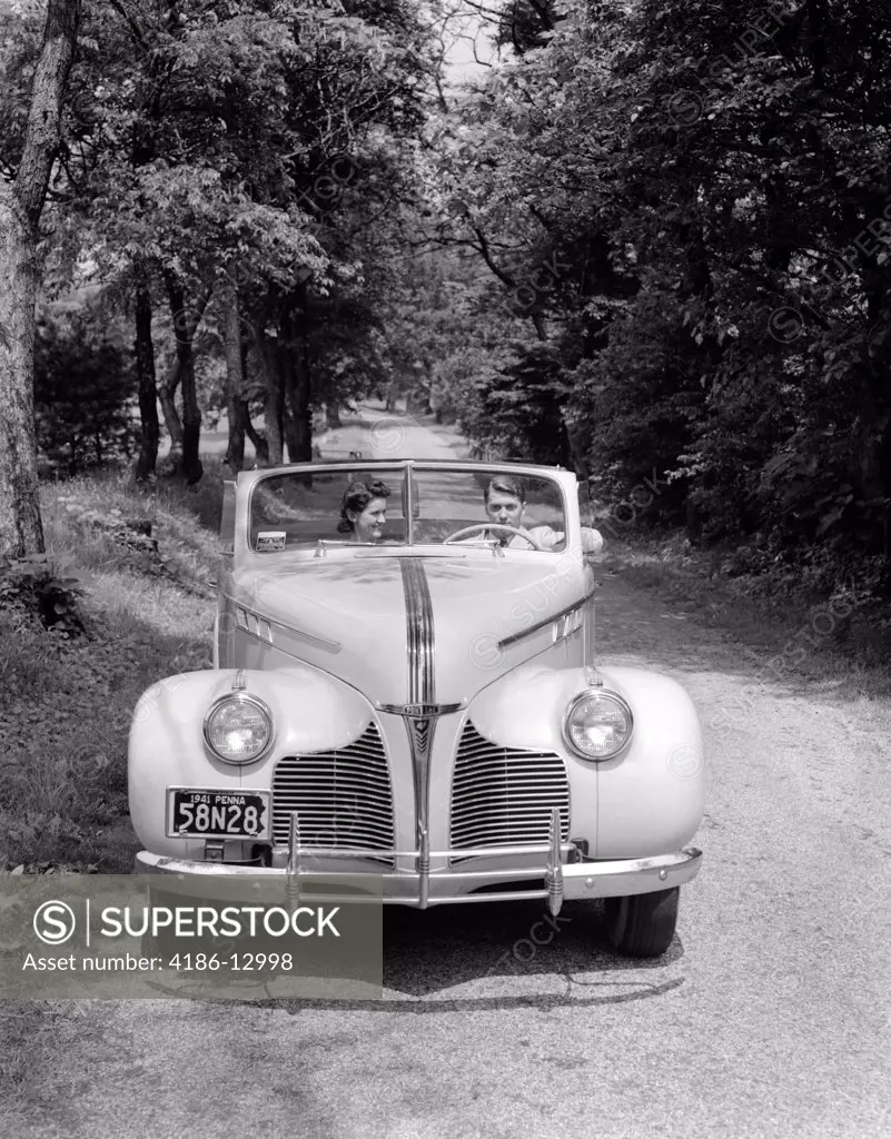 1940S 1941 Couple Man And Woman In Pontiac Convertible Driving On Country Lane In Countryside