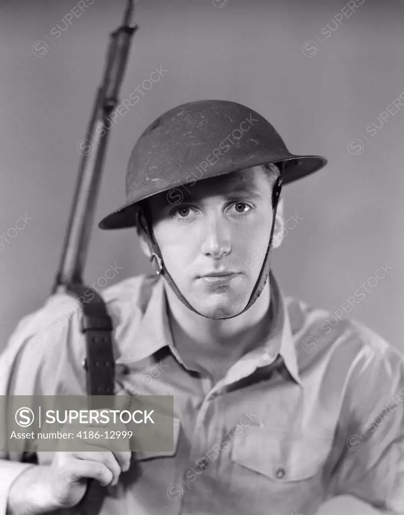 1940S Portrait Of American Man Soldier Serious Expression Gun Rifle On Shoulder Helmet With Chin Strap Ww2 Army Vintage