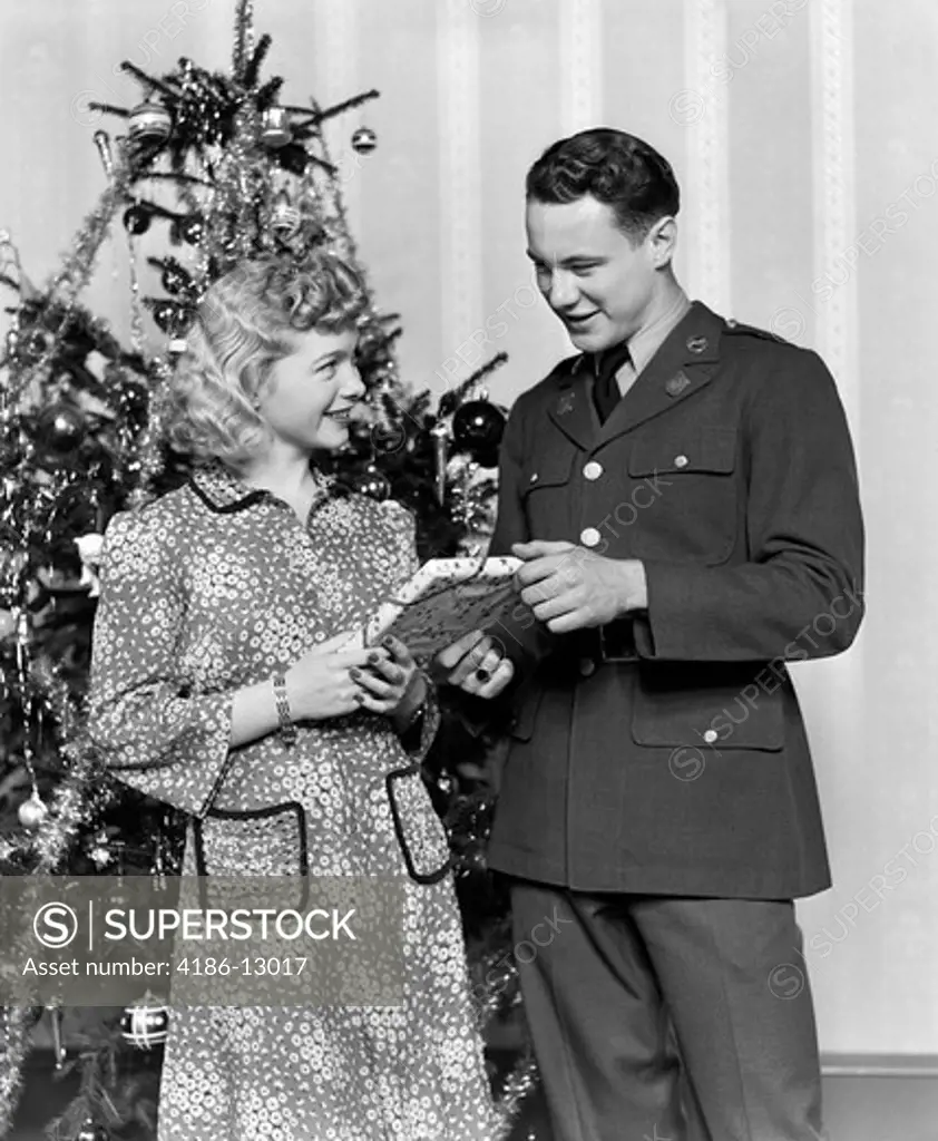 1940S Couple Man Soldier Giving Gift To Woman By Christmas Tree