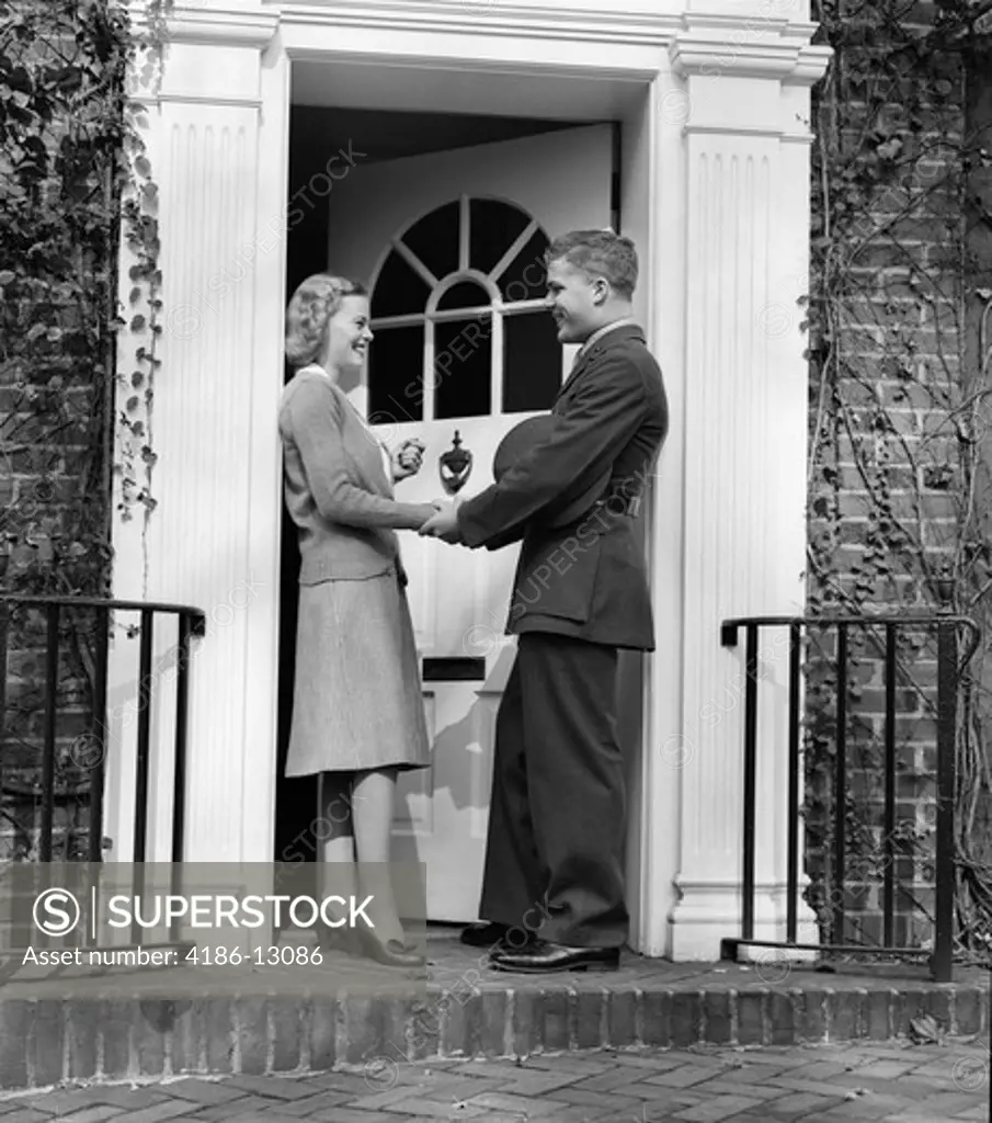 1940S Woman Greeting Man In Soldiers Uniform At Front Door