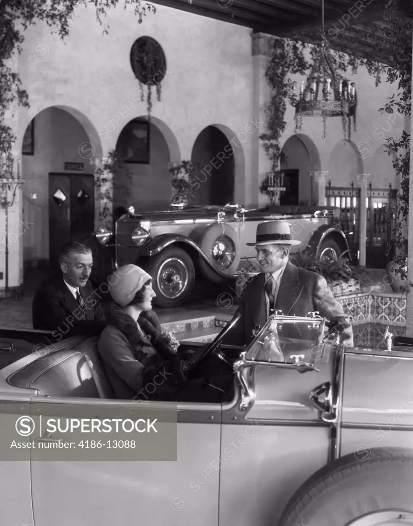 1920S Woman In Driver'S Seat Of Convertible With Husband & Salesman Standing Next To Car In Fancy Showroom