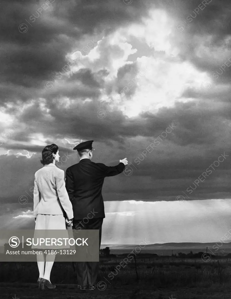 1940S Couple Man Woman Pointing To Sunset Holding Hands Man Wearing Military Uniform