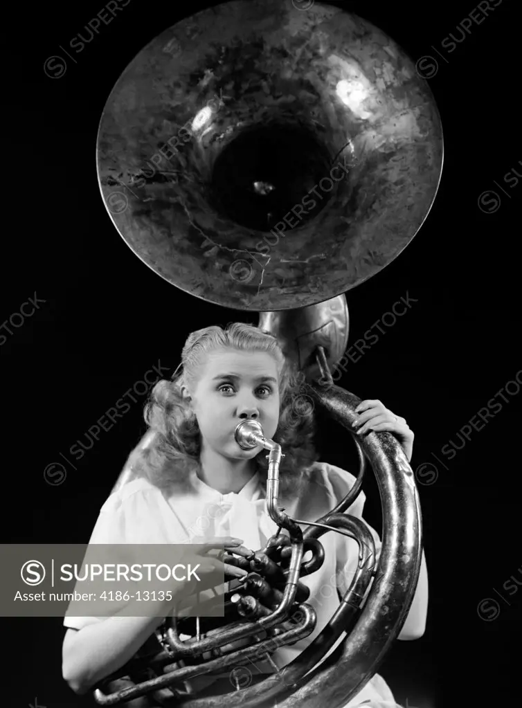 1940S Teenage Woman Blowing And Playing Tuba Horn Musical Instrument With Eyes Wide Open Studio