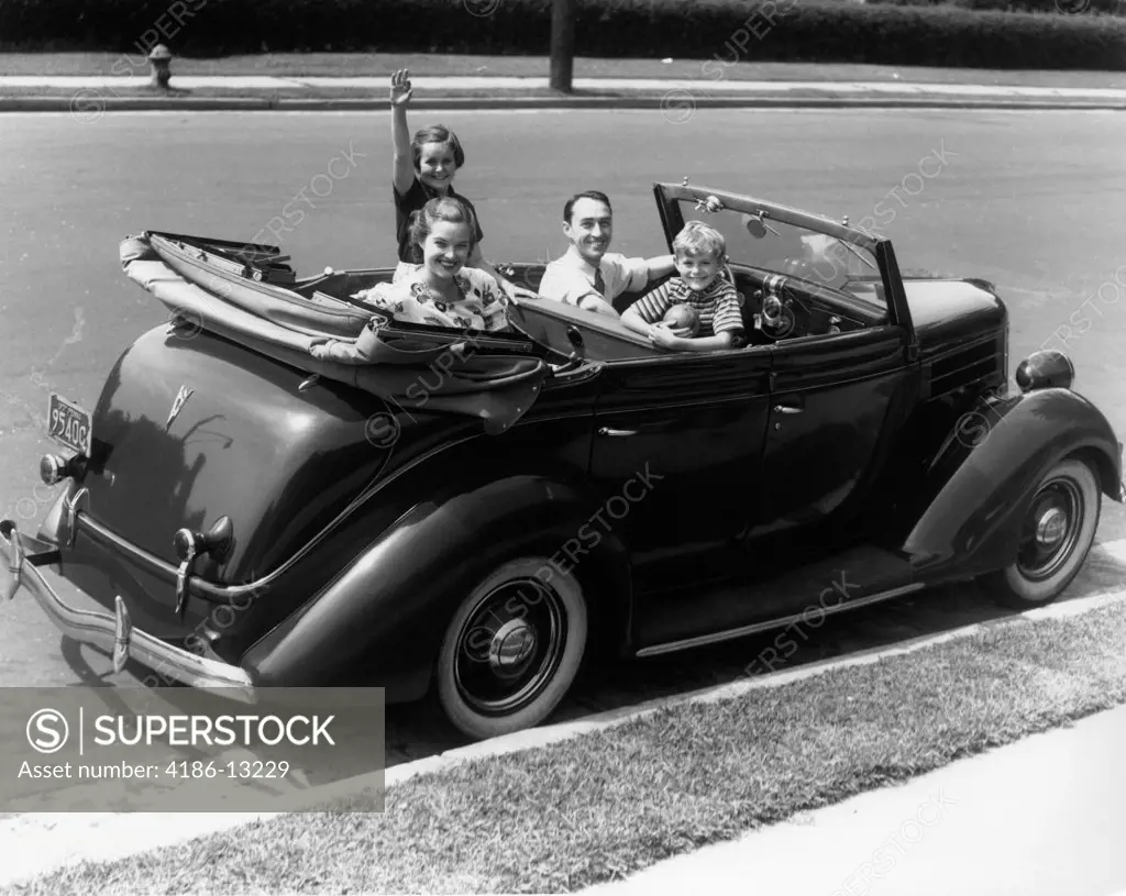 1940S Family Of Four In Convertible Ford V-8 Sedan Smiling At Camera