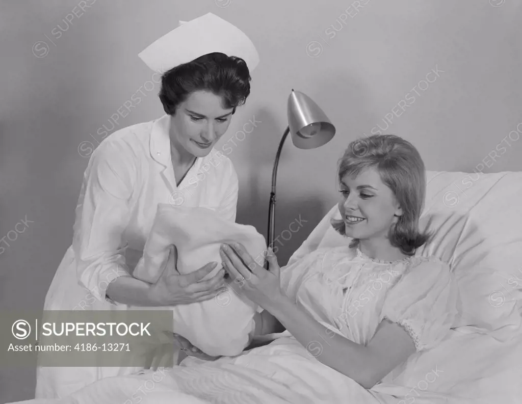 1960S Woman Nurse Giving Baby To Smiling Mother Patient Sitting In Hospital Bed
