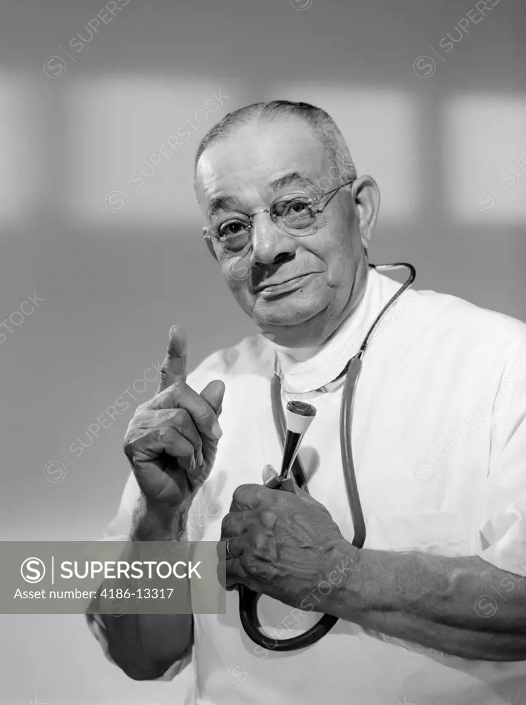1960S Portrait Of Man Doctor Holding Stethoscope And Admonishing With A Raised Finger Of Hand Studio Indoor