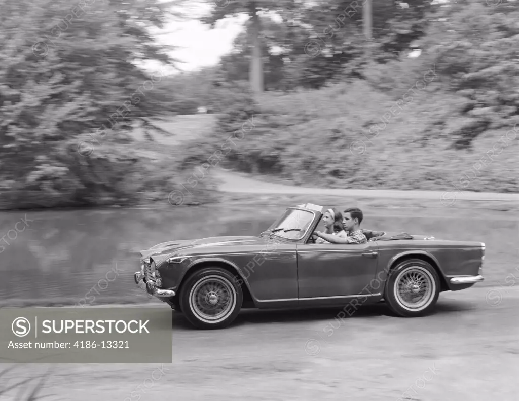 1960S Couple Driving In Convertible Sports Car